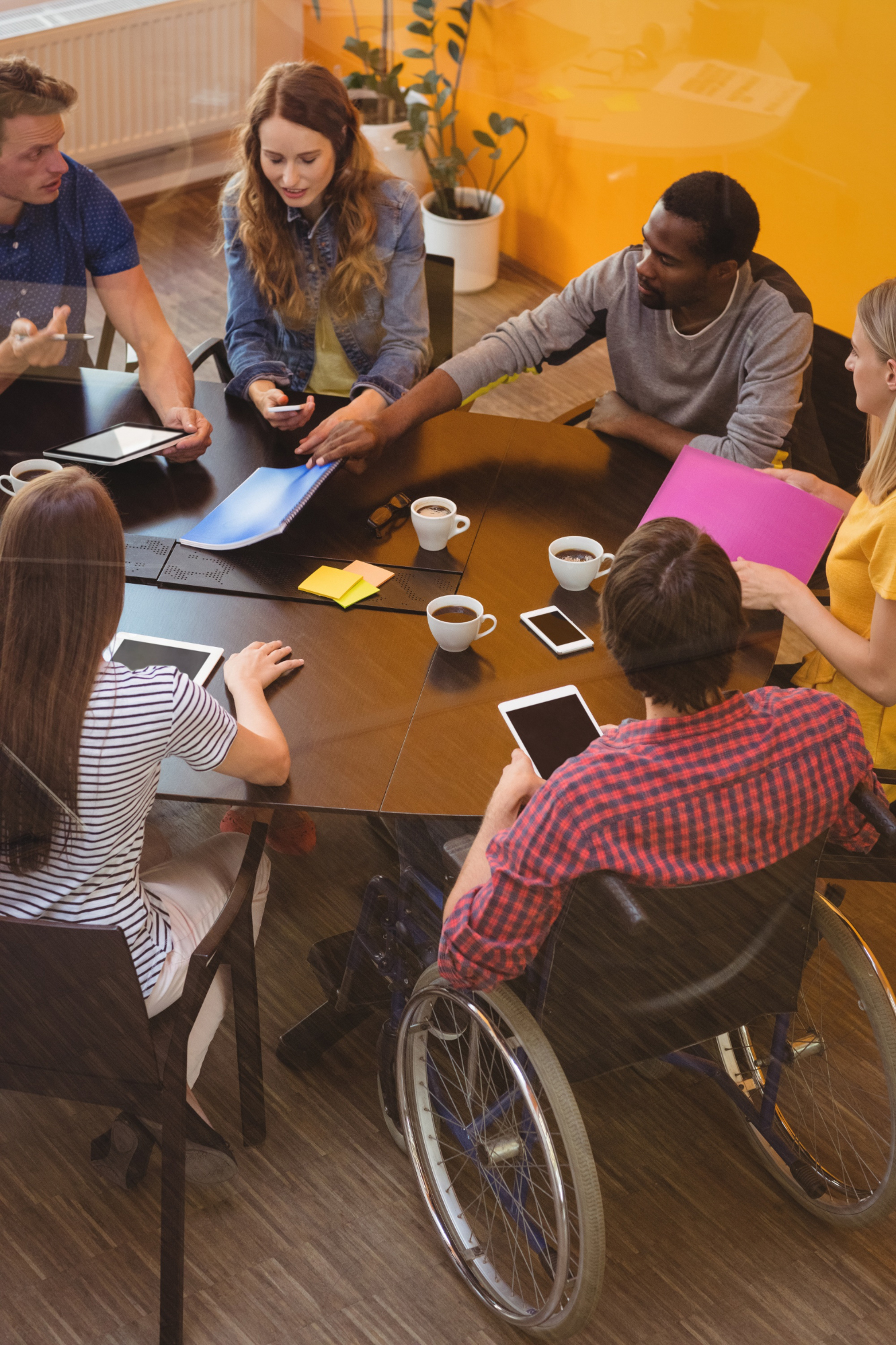 Imagen inclusiva de ejecutivos de negocios que interactúan alrededor de una mesa