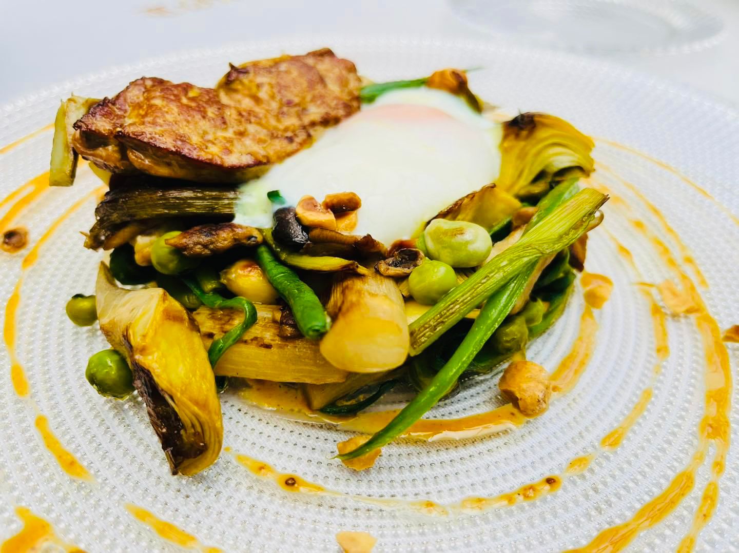 Plato de alcachofas y espárragos salteados al horno con foie, huevo escalfado y avellanas del Restaurante Túbal de Tafalla